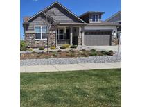 Charming two-story home featuring stone accents, a well-manicured lawn, and an attached two-car garage at 23579 E Swallow Cir, Aurora, CO 80016