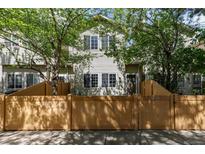Charming townhouse exterior with wood fence, lush green trees, and natural light at 12558 E Tennessee Cir, Aurora, CO 80012