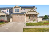 Charming two-story home featuring stone accents, a two-car garage, and solar panels for energy efficiency at 4404 Walden St, Denver, CO 80249