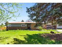 Charming single-story brick home with a well-manicured lawn and mature trees at 6212 S Pennsylvania St, Centennial, CO 80121