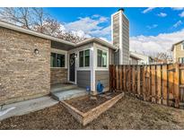 Charming front entrance with brick accents, gray trim, and a welcoming front door with storm door at 5761 W 71St Ave, Arvada, CO 80003