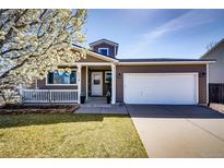 Charming home showcasing a two-car garage and well-maintained front yard with flower tree in full bloom at 2070 E 125Th Pl, Thornton, CO 80241