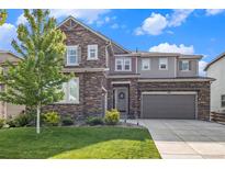 Charming two-story home with stone accents, a landscaped yard, and a welcoming front entrance at 1195 Fox Hills Ct, Erie, CO 80516