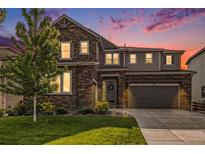 Beautiful two-story home featuring a stone facade, well-manicured lawn, and an attached two-car garage at 1195 Fox Hills Ct, Erie, CO 80516