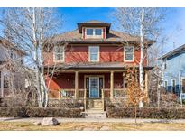Charming two-story home with a front porch, mature trees, and a well-maintained lawn at 2853 Yosemite St, Denver, CO 80238