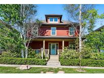 Charming red two-story home with inviting front porch and well-manicured landscaping at 2853 Yosemite St, Denver, CO 80238
