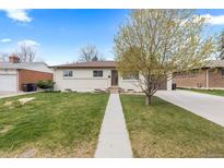 Charming single-story home with a well-manicured lawn and a concrete walkway leading to the front door at 3055 S Winona Ct, Denver, CO 80236