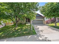 Charming home with a two-car garage, mature trees, and a well-maintained lawn at 5932 S Versailles St, Aurora, CO 80015