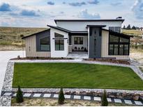 Stunning modern home featuring manicured lawn, stone accents and a unique architectural design at 8765 Canyon Wind St, Parker, CO 80138