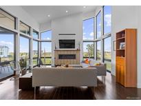Bright living room featuring floor-to-ceiling windows, fireplace, and modern furniture at 8765 Canyon Wind St, Parker, CO 80138