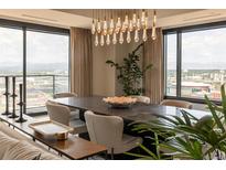 Bright dining room featuring a modern chandelier, large windows with city views, and stylish decor at 1133 14Th St # 2000, Denver, CO 80202
