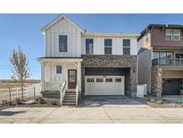 Charming two-story home with a two-car garage, stone accents, and covered front porch at 2150 S Haleyville Way, Aurora, CO 80018