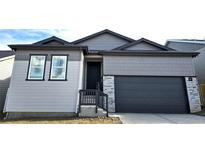 New construction shows a Craftsman style home in gray with stone accents and a two car garage at 17136 W 92Nd Loop, Arvada, CO 80007