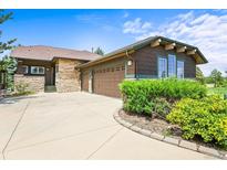 Charming single-Gathering home showcasing a stone and brown exterior, complemented by a spacious driveway and lush landscaping at 23961 E Easter Pl, Aurora, CO 80016