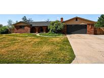 Charming brick home featuring arched entryway, a well-manicured lawn, and attached two-car garage at 14793 E Hampden Pl, Aurora, CO 80014