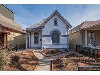 Charming home with a well-kept front yard, a walkway, and a painted brick facade at 124 Elati St, Denver, CO 80223