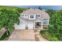 Beautiful two-story home featuring a three-car garage, well-manicured lawn and a covered entryway at 7866 Witney Pl, Lone Tree, CO 80124
