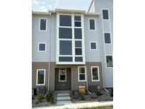 Charming townhome featuring a modern exterior design with large windows and landscaped front yard at 14223 Currant St, Broomfield, CO 80020