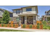Charming two-story home featuring a stone facade, covered porch, and a fenced front yard at 764 N Quatar St, Aurora, CO 80018