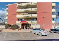 Exterior view of a multi-story building with covered entrance, tidy landscaping and ample parking at 4600 E Asbury Cir # 109, Denver, CO 80222