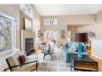 Bright living room boasts high ceilings, fireplace, and comfortable seating area at 2304 S Holly St # A, Denver, CO 80222