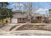 Charming two-story home with brick and siding, a well-manicured lawn, and a blossoming tree in the front yard at 537 S Grape St, Denver, CO 80246