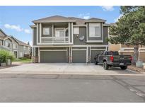 Modern townhome showing multiple garage doors and a pickup truck parked in the driveway at 1409 Carlyle Park Cir, Highlands Ranch, CO 80129