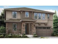 Charming two-story home featuring stone accents, a covered entry, and a two-car garage at 14583 Hudson Way, Thornton, CO 80602