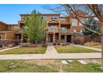 Inviting townhomes with stone accents, private balconies, and well-maintained front yards at 5574 W 72Nd Dr, Arvada, CO 80003