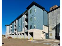 Modern apartment building with blue siding and black trim, set against a clear blue sky at 9283 Twenty Mile Rd # 308, Parker, CO 80134