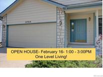 Charming home featuring a two-car garage and inviting light blue front door at 9784 W Euclid Dr, Littleton, CO 80123