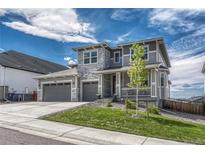 Charming two-story home with a three-car garage, stone accents, and a welcoming front porch at 2775 Morningbird Ln, Castle Rock, CO 80109