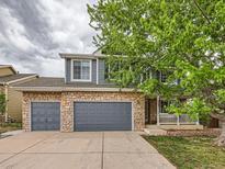 Two story home features a brick and siding exterior, two car garage and a charming porch at 5163 Apache Creek Rd, Castle Rock, CO 80109