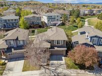 Inviting suburban home featuring a manicured lawn and mature trees on a sunny day at 10657 Cherrybrook Cir, Highlands Ranch, CO 80126