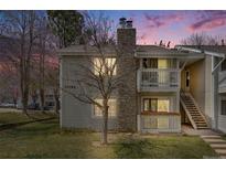 Charming condo with a stone chimney, two balconies, a well-kept lawn, and stairs to the upper level at 14192 E Colorado Dr # 102, Aurora, CO 80012