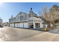 Gray two-story townhouse with white trim, garage, and a car parked underneath the second story balcony at 6600 E Mississippi Ave # 7, Denver, CO 80224