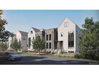 Modern townhome exteriors featuring neutral siding, modern windows and manicured landscaping with a blue car in the drive at 580 Lombardi Cir, Louisville, CO 80027
