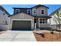 Charming two-story home featuring a spacious garage, welcoming porch, and well-manicured landscaping for enhanced curb appeal at 449 S Salida St, Aurora, CO 80017