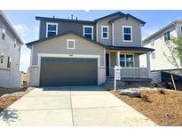 Charming two-story home featuring a two-car garage, covered porch and manicured front yard at 449 S Salida St, Aurora, CO 80017