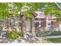 Inviting townhouse entrance with stone accents and a charming covered patio area at 15501 E 112Th Ave # 28E, Commerce City, CO 80022