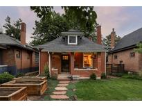 Charming brick home featuring a well-manicured lawn and inviting front entrance at 4430 Zuni St, Denver, CO 80211