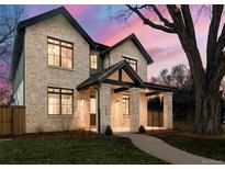 Two-story brick home with a covered porch and landscaped yard at 1149 S Madison St, Denver, CO 80210