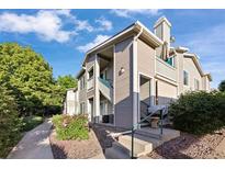 Attractive condo showcasing well-maintained siding, entry stairs, landscaping, and charming curb appeal at 3857 Mossy Rock Dr # 201, Highlands Ranch, CO 80126