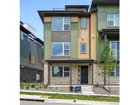 Modern townhouse with multi-tone exterior, stone accents, and manicured front yard at 815 Promenade Dr, Superior, CO 80027