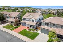 Inviting two-story home with manicured lawn and a cozy front porch, complete with a two-car garage and a red driveway at 2307 Candleglow St, Castle Rock, CO 80109