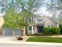 Charming two-story home with brick and gray siding, mature trees, manicured lawn, and an attached two-car garage at 2990 E 135Th Dr, Thornton, CO 80241