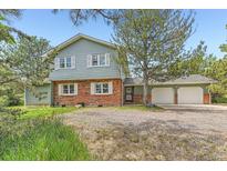 Charming two-story home featuring a brick facade, white shutters, and a spacious three-car garage at 6351 S Andes Pl, Centennial, CO 80016