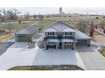 Charming two-story home featuring a spacious driveway, stone accents, manicured lawn and a detached garage at 16110 Poplar St, Brighton, CO 80602
