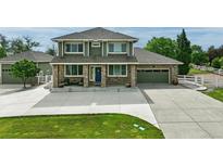 Charming two-story home with a brick-accented facade, well-manicured lawn, and a spacious driveway at 16110 Poplar St, Brighton, CO 80602