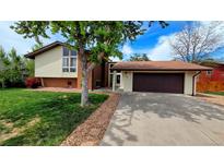 Charming home featuring a well-manicured lawn, attached two-car garage, and a mix of brick and siding at 1821 E Kettle Ave, Centennial, CO 80122